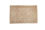 Distressed vintage Tajabad rug with hexagonal medallion and intricate faded vines in soft beige and pale pink.