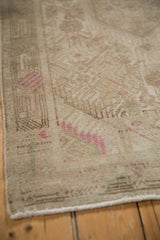 Distressed Tajabad rug corner showing faded beige, pale magenta pattern, and side selvage.
