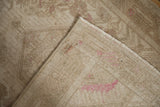Distressed beige and pink pile, revealing the robust original side cord selvage of the Vintage Tajabad rug.