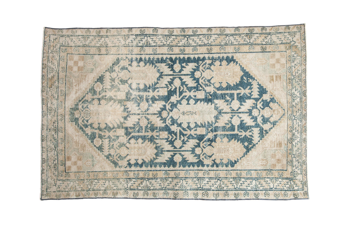 Vintage distressed Hamadan rug with a large dusty blue medallion and floral palmettes over a worn ivory and sand field.