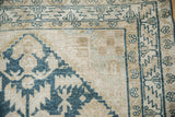 Close-up of the distressed corner on a vintage Hamadan rug with geometric borders.