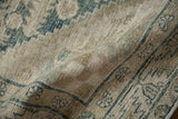 A close view of the time-softened texture and low, worn pile on a vintage Hamadan rug.