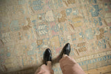 View of the distressed Persian runner's low pile, highlighting heavy abrashes and faded pastel tones.