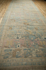Full length view of a distressed Persian runner, highlighting its even wear and soft color palette.