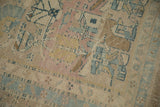 Close-up view of the even wear and low pile on a vintage Persian rug with dusty mauve motifs.