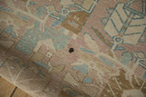 A dark spot on the worn, hand-knotted pile of a distressed Northwest Persian rug.