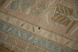 A small blemish on the worn, hand-knotted pile of the distressed Persian rug.