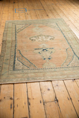 Angled view of a distressed vintage Persian rug showing its unidirectional vase design.