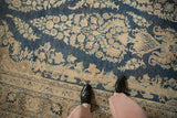 Distressed vintage Meshed rug with navy and cream floral motifs and visible foundation wear.