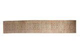 Vintage distressed Lilihan rug runner with a floral blossom pattern in terracotta and faded silver.
