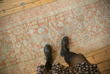 Evenly worn, low pile texture of a distressed Lilihan runner with terracotta and silver florals.