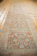 Lengthwise perspective of a distressed Persian Lilihan runner with faded floral medallions.