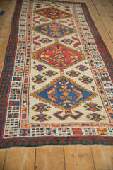 Vintage Serab runner angled to show the repeating red and blue diamond medallions down its length.