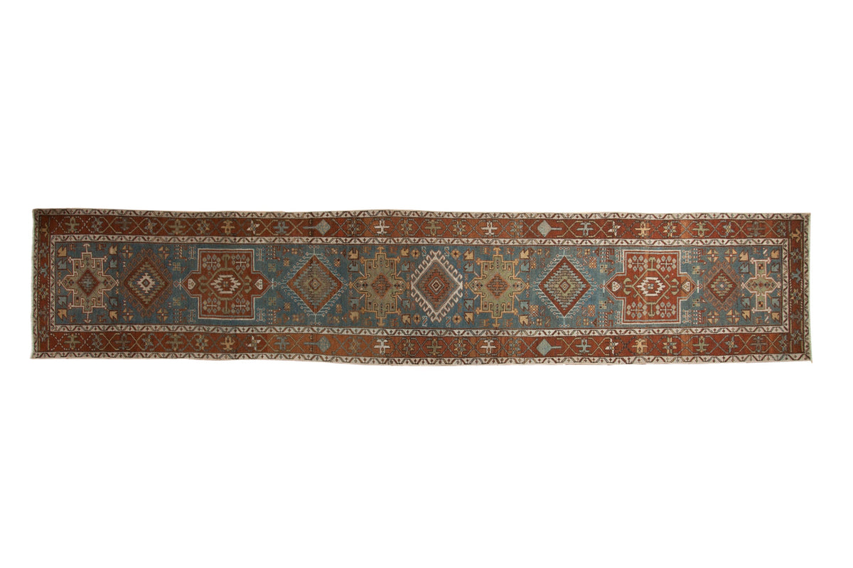 Vintage distressed Karaja runner with a single column of alternating medallions in dusty teal and chestnut.