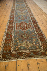 Long perspective view of a distressed Karaja runner's repeating geometric medallions.