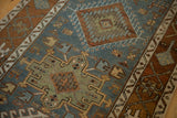 Geometric medallions and Samovar plant borders on a distressed Persian Karaja runner in teal and chestnut.