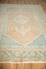 Low-angle view of a distressed Hamadan rug highlighting its even wear and soft geometric design.