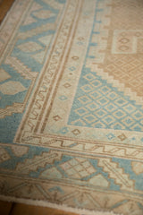 Evenly worn pile on a vintage rug's border with geometric designs in sky blue and brown.