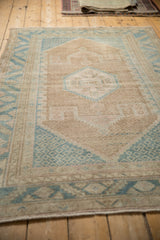 Long perspective view of a vintage distressed Hamadan rug with a faded, geometric design.