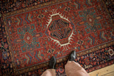 Geometric triple medallion and floral motifs on a vintage Persian Karaja rug with even wear.