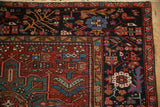 Vintage Karaja rug corner with a densely ornamented dark border next to the madder red field.