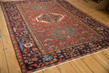 Angled view of a vintage Karaja rug's geometric triple medallion and densely patterned border.