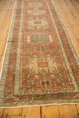 Perspective view down a vintage Karaja runner, showcasing its column of distressed geometric medallions.