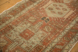 Mostly even wear across the knot heads of a distressed Karaja rug in rust and seafoam green.