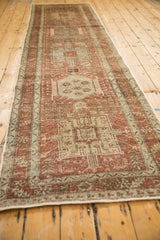 Angled full-length view of a vintage Karaja runner's repeating geometric medallions.