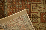 Folded corner of the distressed Persian rug revealing its foundation and restored side cording.