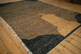 Angled view of an abstract Afghani rug showing its varied high-low pile and checkered design.