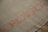 Even wear on the low pile and soft terracotta border of a distressed Khotan carpet.