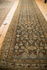 Angled perspective showing the full length of a distressed Persian Hamadan rug runner.