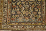 Worn texture of a vintage Hamadan corner showing its Herati motif field and geometric borders.
