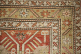 Geometric starburst motif within the meandering vine border of an antique Caucasian rug.