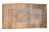 Vintage distressed Sivas carpet with a scalloped medallion on a floral field in dusty teal and sand.