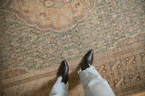 Worn, low pile texture of a vintage Sivas carpet showing dusty teal and sand floral motifs.