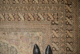 Floral border and worn, low-pile texture of a vintage distressed Sivas carpet corner.