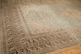Complex floral borders in sand and brown on a distressed vintage Turkish Sivas carpet.