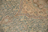 Detail of the worn pile and scalloped floral medallion on a distressed Sivas carpet.