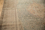 Angled detail of the sewn-on border and worn pile of the distressed Sivas carpet.