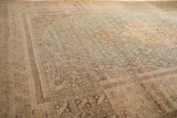 Close-up of a distressed Sivas carpet showing heavy abrashes and worn texture in sand and teal.