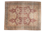 Vintage distressed Kerman carpet with burgundy trefoil overlays and a dusty teal border on an ivory field.