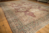 Angled view of a Kerman rug's distressed Samovar design and teal border.