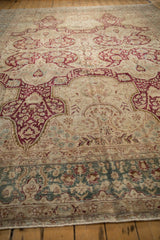 Textured pile of a vintage distressed Kerman carpet, with a dusty teal border in the foreground.