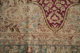 Distressed texture of a vintage Kerman carpet with foundation visible through burgundy and teal motifs.