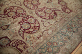 Storied texture of a distressed Kerman rug highlighting the burgundy Samovar motifs and teal border.