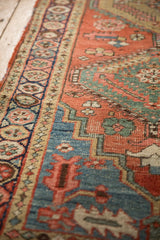 Textured close-up of antique Northwest Persian runner's brick red field and pomegranate border.