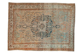 Distressed Baktiari carpet with a navy medallion on an abrashed sand, powder blue, and copper field.