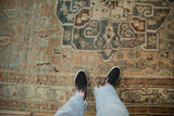 Distressed Baktiari carpet detail showing low pile, white knots, and a sand and dusty blue palette.